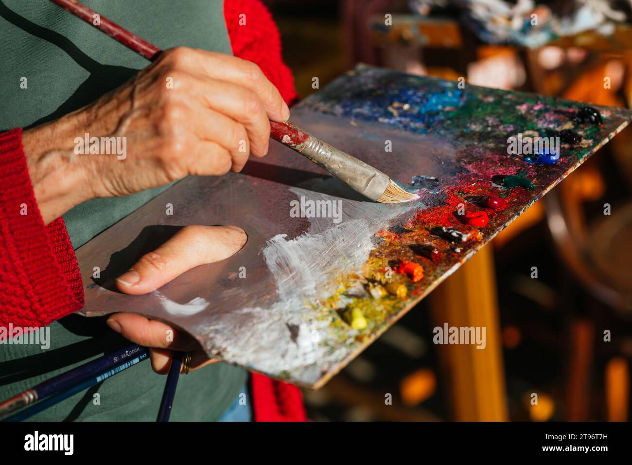 Von oben der Ernte unkenntlich ältere weibliche Malerin mischen Farben auf Farbpalette in der Kunstwerkstatt Stockfoto