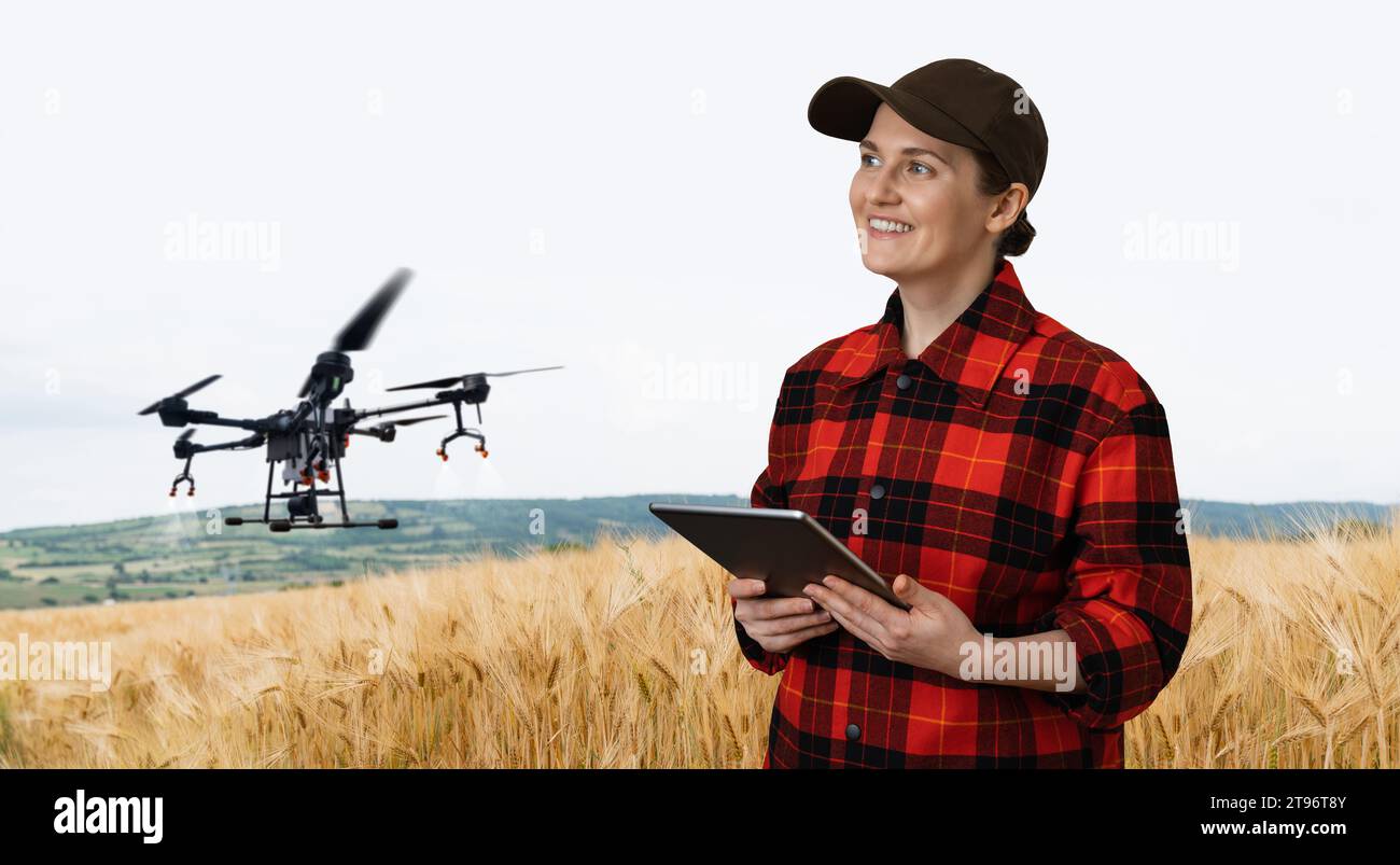 Landwirtin steuert Drohnensprühgerät mit einem Tablet. Intelligente Landwirtschaft und Präzisionslandwirtschaft. Stockfoto