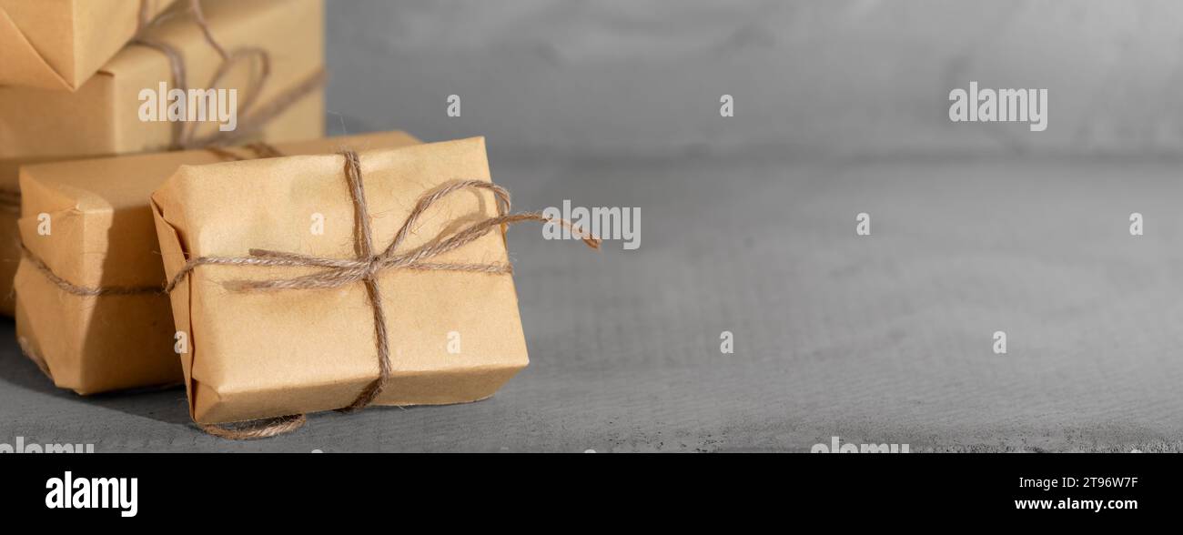 Weihnachtsgeschenke auf dunklem strukturiertem Hintergrund. Weihnachtsgrußkarte mit Kopierraum Stockfoto