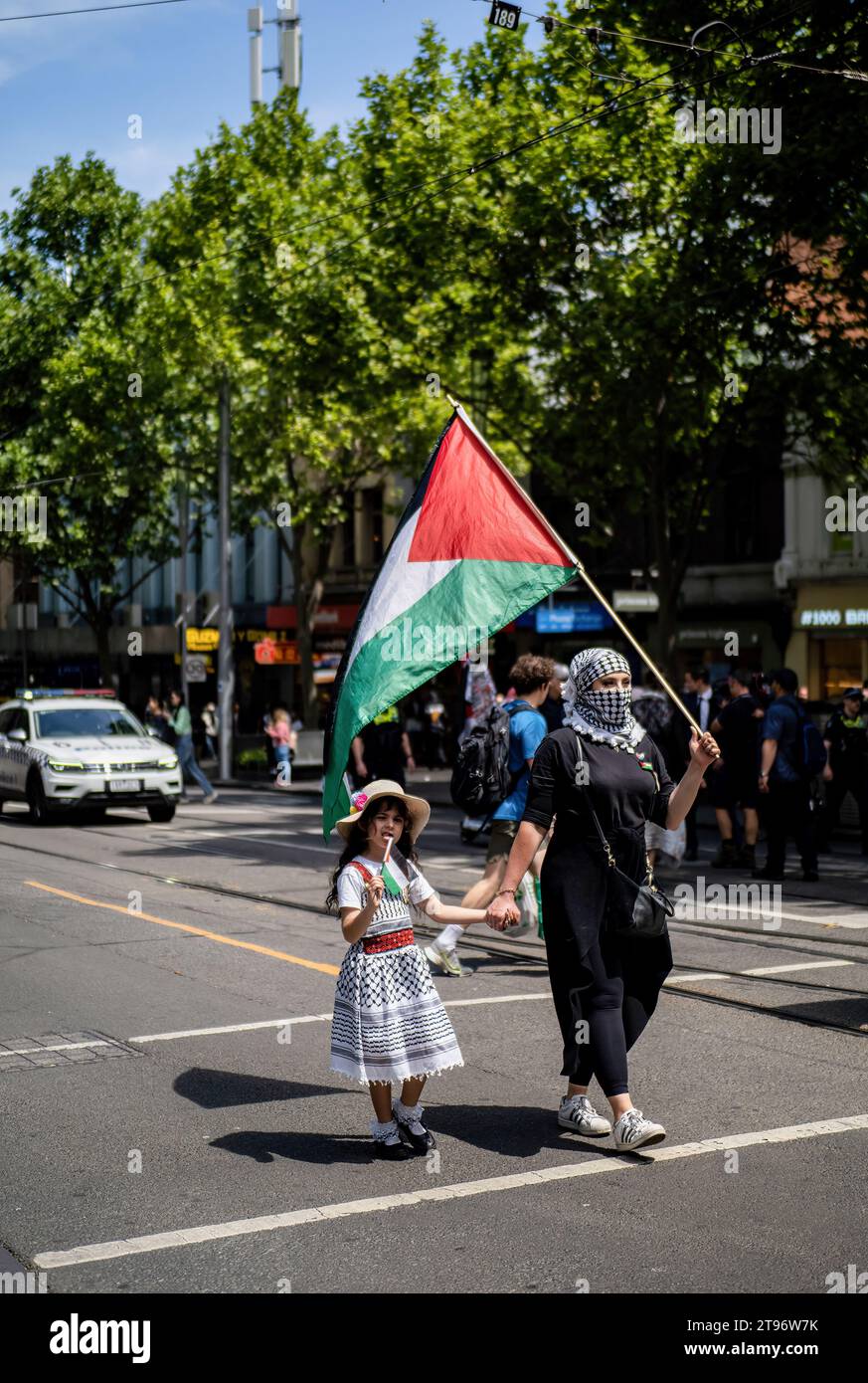 Melbourne, Australien. November 2023. Ein kleines Kind mit ihrer Mutter marschiert am Ende der Demonstration zusammen. Hunderte von Schülern der Grund- und Sekundarstufe nehmen an einem „Schulstreik“ Teil, der aus dem Unterricht geht und sich im Stadtzentrum trifft, um ihre Solidarität mit der palästinensischen Sache auszudrücken und ein Ende des israelisch-Hamas-Krieges zu fordern. Credit: SOPA Images Limited/Alamy Live News Stockfoto