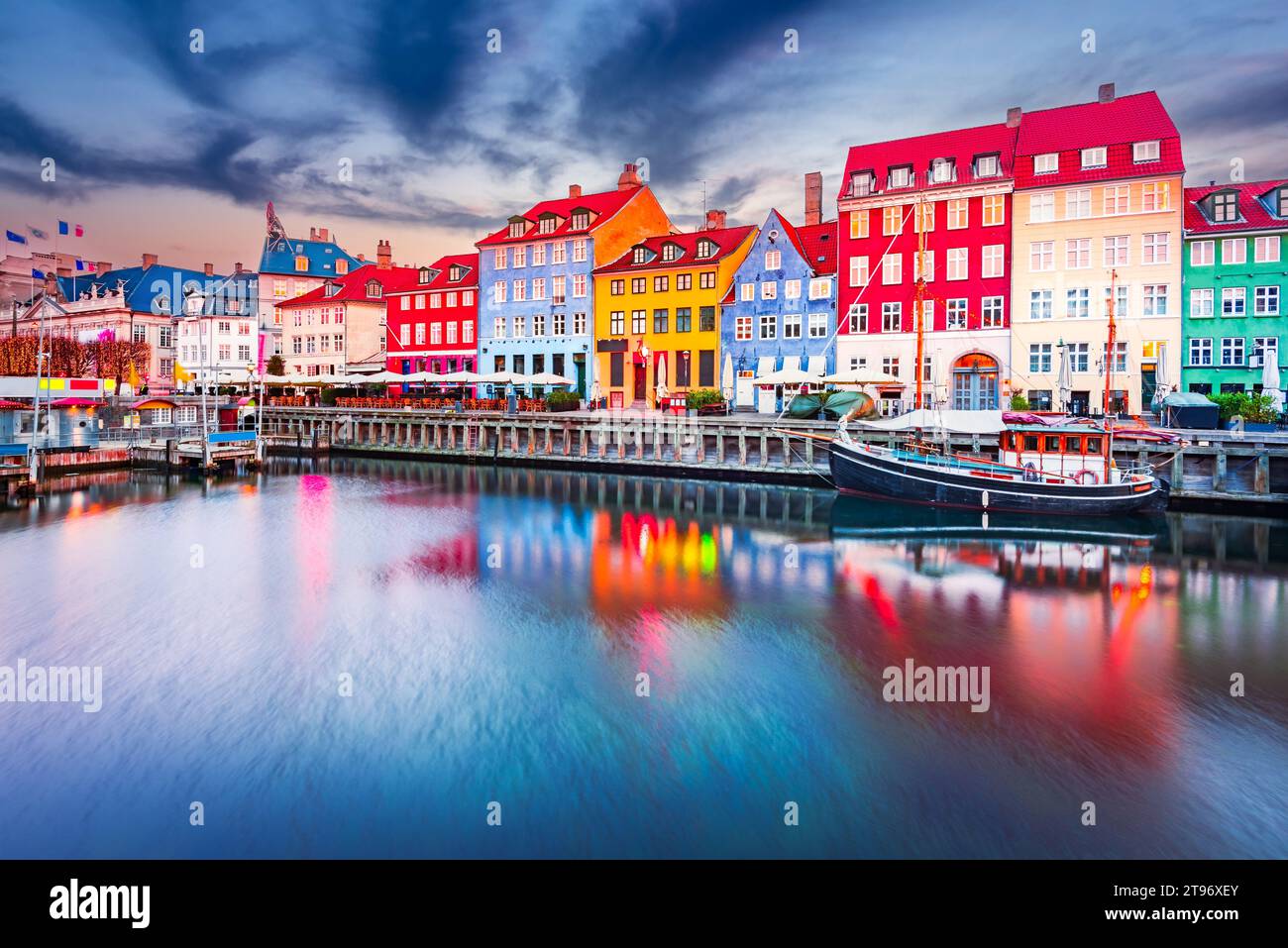 Der Charme von Kopenhagen, Dänemark in Nyhavn. Legendärer Kanal, farbenfrohes Nachtbild und atemberaubende Wasserreflexionen. Stockfoto