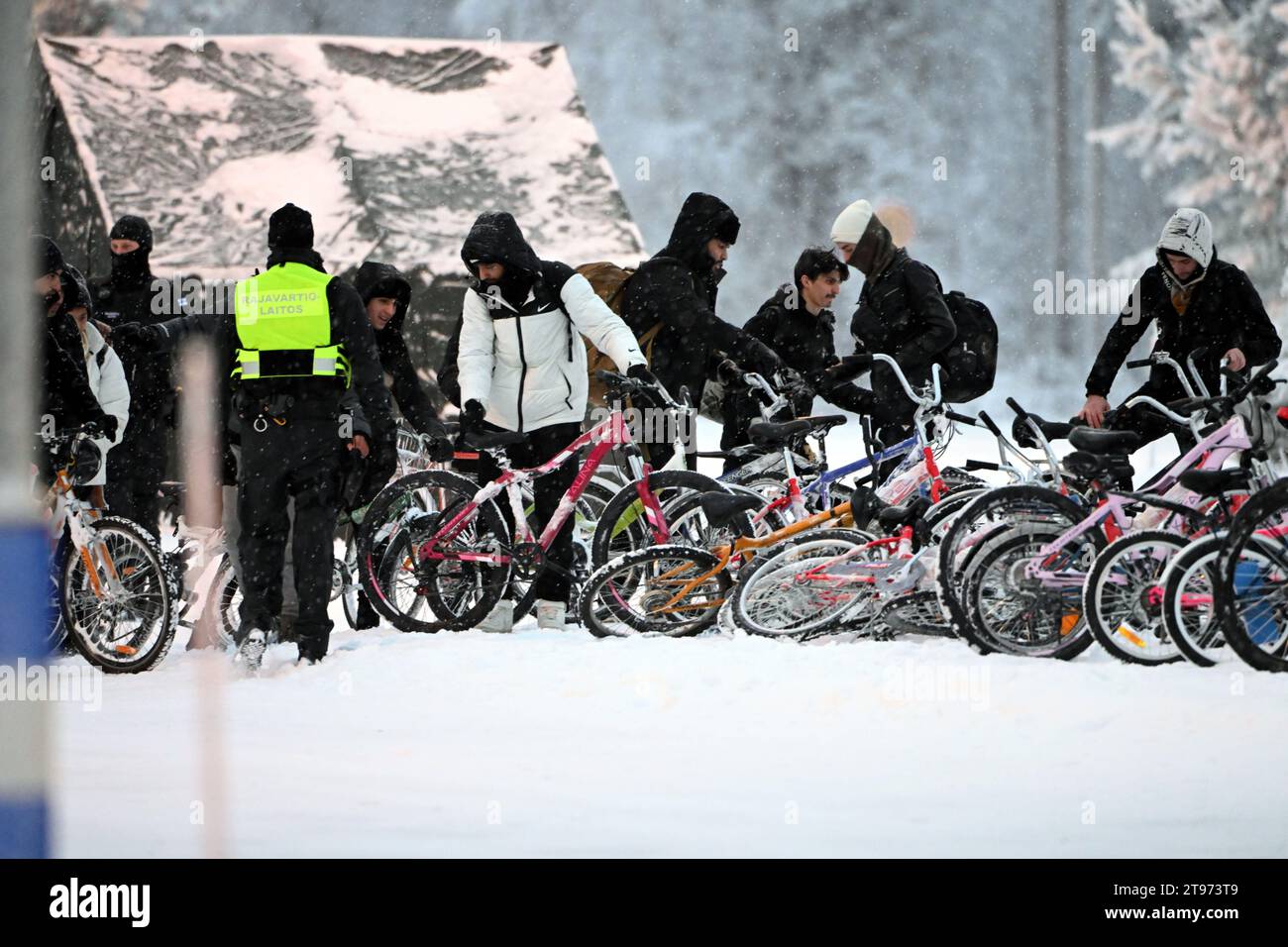 Salla, Finnland. November 2023. Migranten kommen am 23. November 2023 mit Fahrrädern zum internationalen Grenzübergang nach Salla, Nordfinnland. Die meisten Migranten kommen nun an den nördlichen Grenzstationen zwischen Finnland und Russland an, da Finnland mehr Grenzübergänge an seiner östlichen Grenze aufgrund des Zustroms von Migranten aus Drittländern über Russland schließt. (Foto: JUSSI NUKARI/LEHTIKUVA/SIPA USA) Credit: SIPA US/Alamy Live News Stockfoto