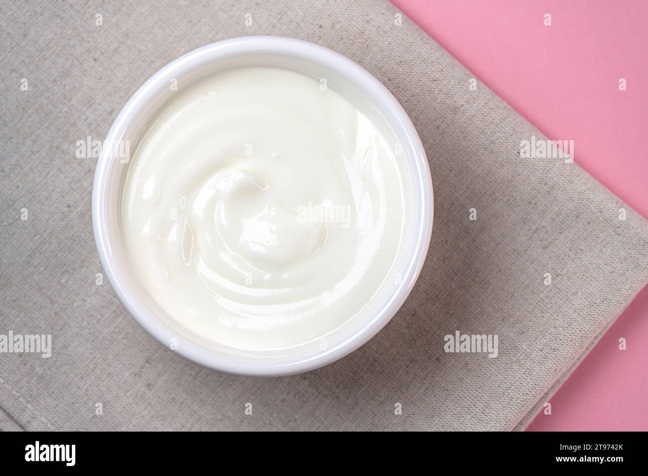 Weiße Keramikschale mit frischem Sauerrahm, Joghurt auf einem Tisch, Blick von oben Stockfoto