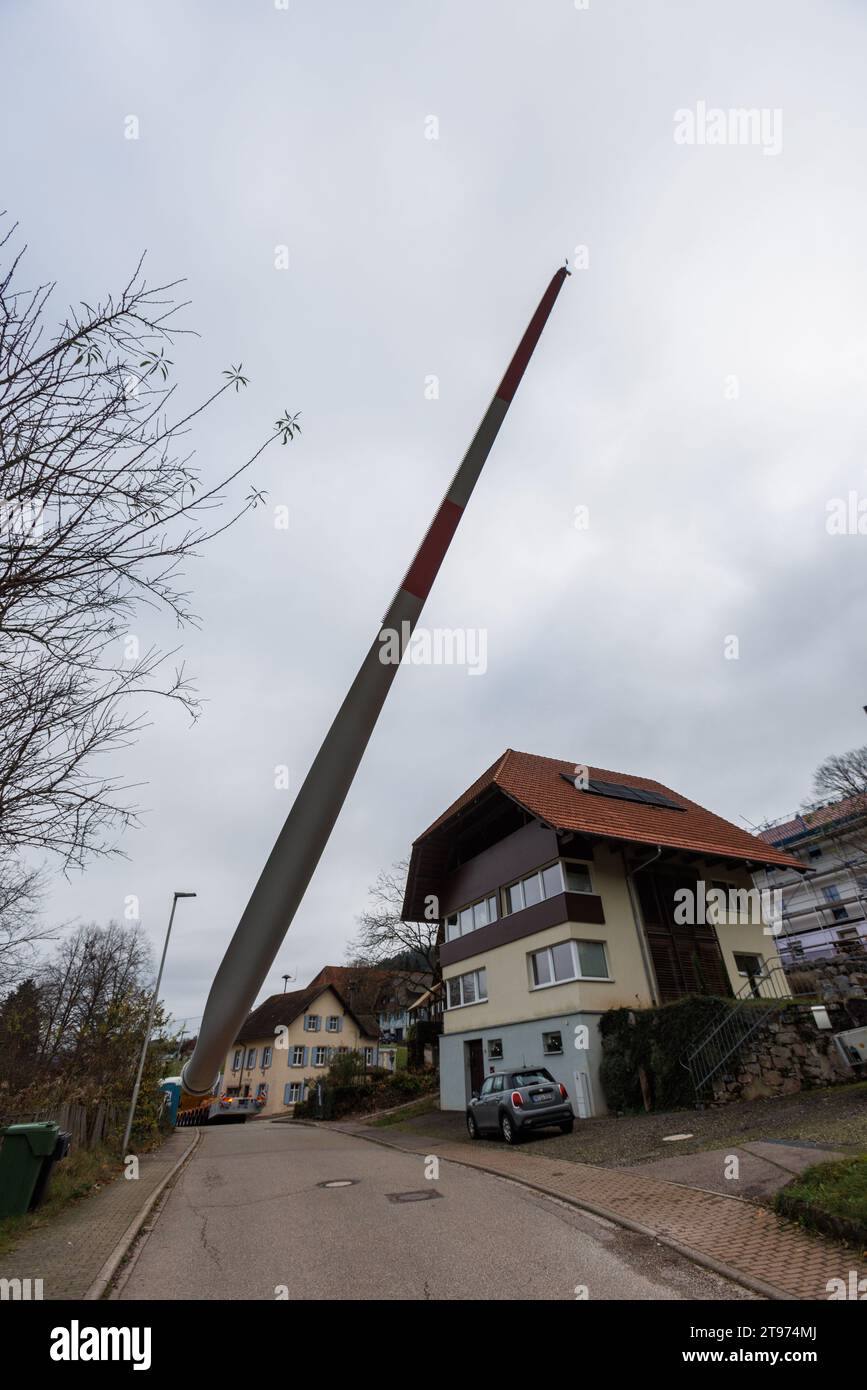 Biberach, Deutschland. November 2023. Auf einem sogenannten selbstfahrenden Transporter wird ein Windenergieblatt montiert und durch das Dorf Prinzbach transportiert. Insgesamt sollen drei 68 Meter lange Rotorblätter aus Biberach über eine Entfernung von rund sieben Kilometern transportiert werden. Nach Angaben des Energieversorgers Badenova sind millimetergenaue Arbeiten erforderlich, um sicherzustellen, dass die Rotorblätter unbeschädigt auf der Baustelle ankommen. An einigen Stellen entlang der Strecke muss eine Steigung von 12 Prozent gemeistert werden. Quelle: Philipp von Ditfurth/dpa/Alamy Live News Stockfoto