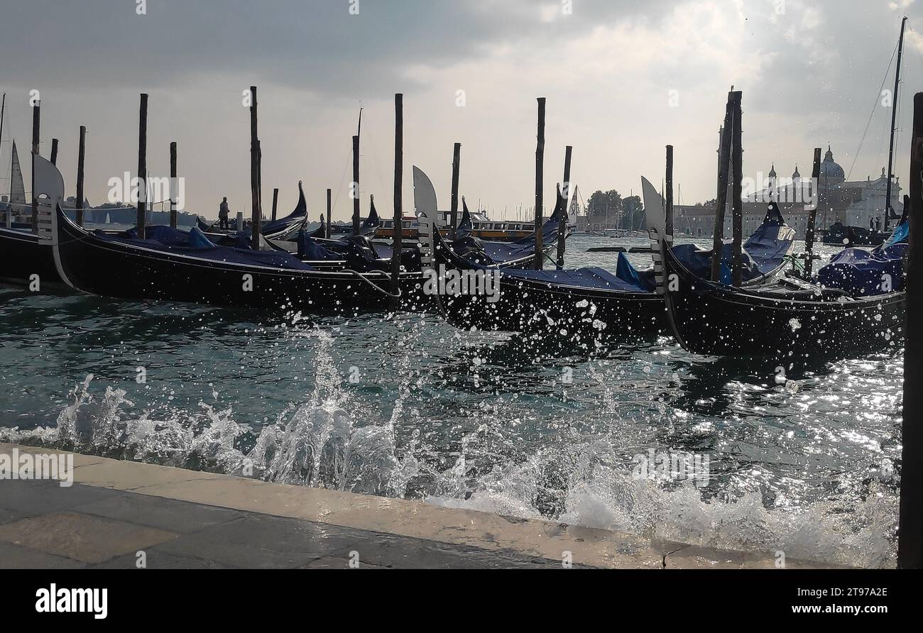 Gondeln in venedig. Gruppe Gondeln, die vom Meer geschüttelt werden. Wasserspritzer. Stockfoto