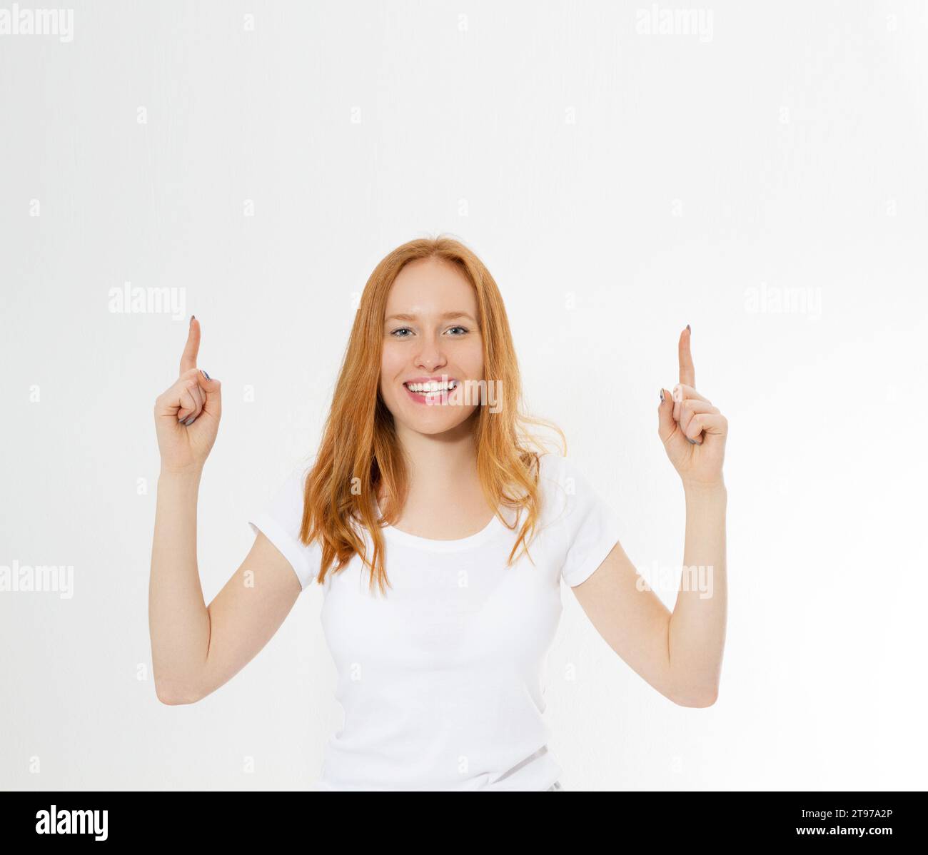 Foto-lächelnde Dame mit roten Haaren auf weißem Hintergrund, die ihre Finger nach oben zeigt und eine großartige innovative Idee, Verständnis oder Lösung hat, die sie gerade hat Stockfoto