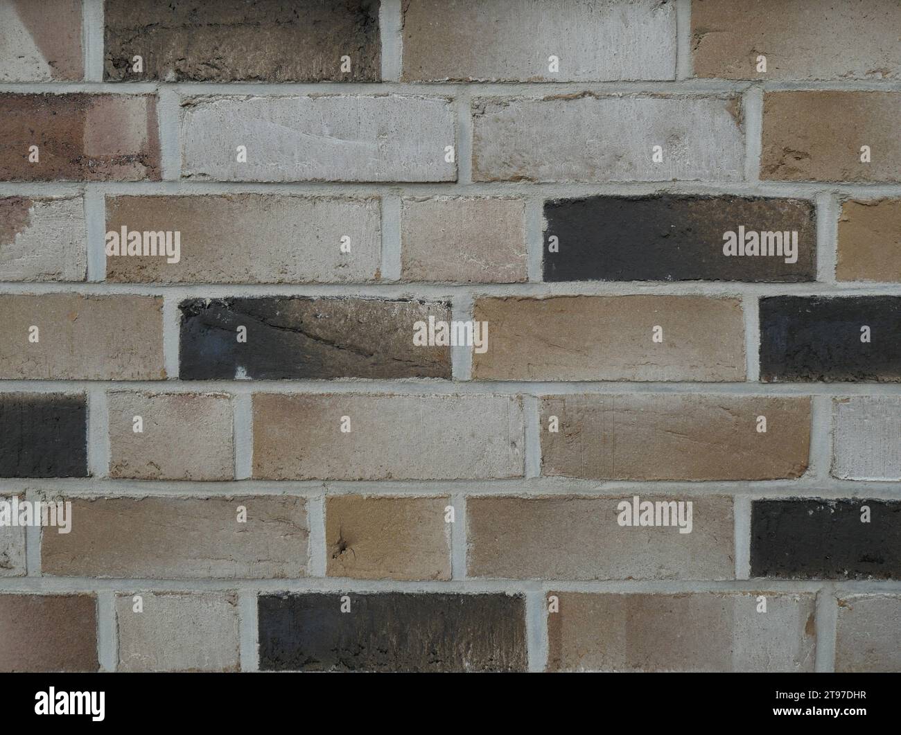 Die Textur einer modernen Mauerwerksfassade besteht aus hell- bis dunkelbraunen Ziegeln. Stockfoto