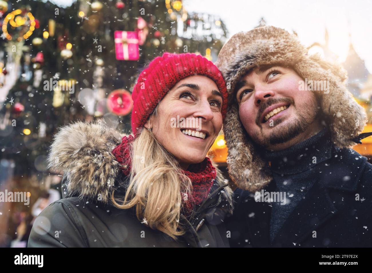 Glückliches Paar Touristen auf dem Weihnachtsmarkt vor dem Baum im Winter Stockfoto