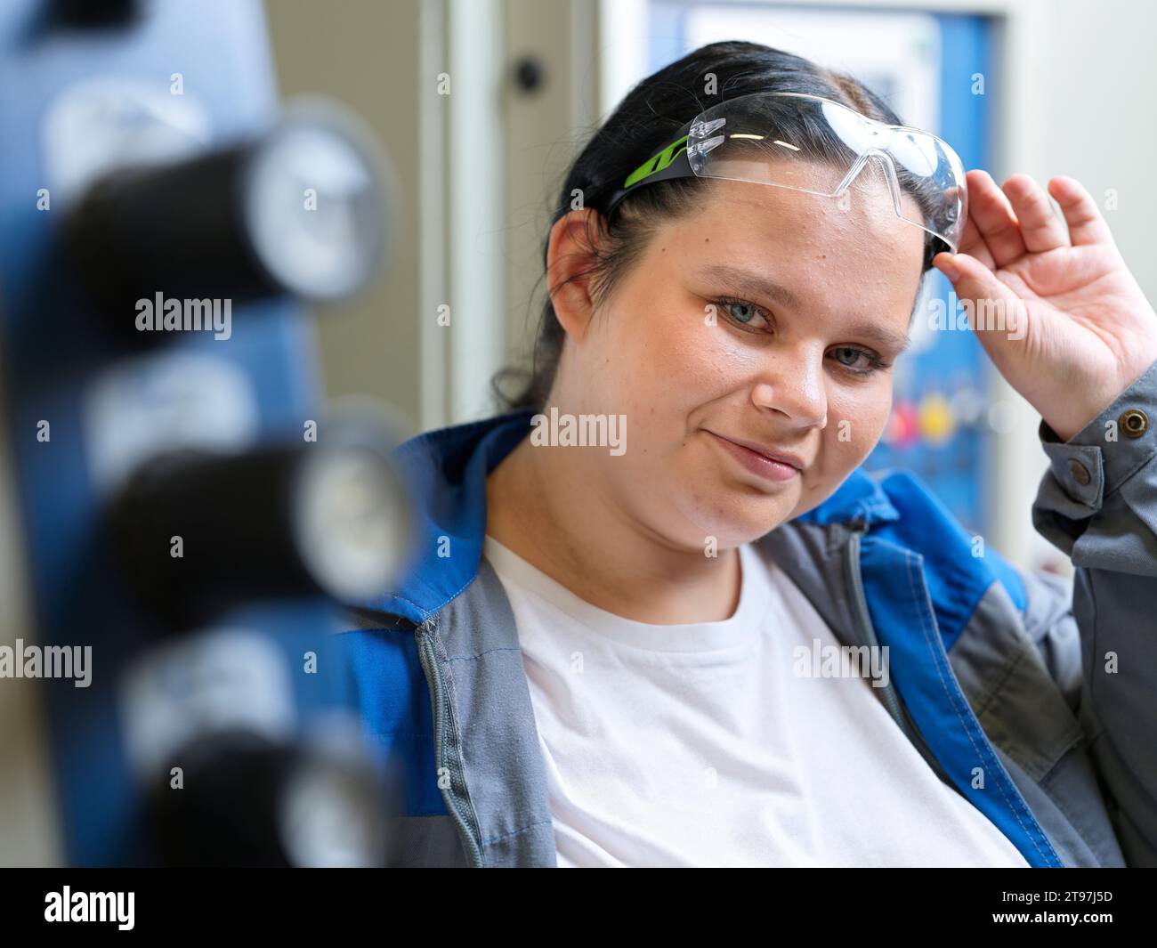 Lächelnder Lehrling mit Schutzbrille in der Werkstatt Stockfoto