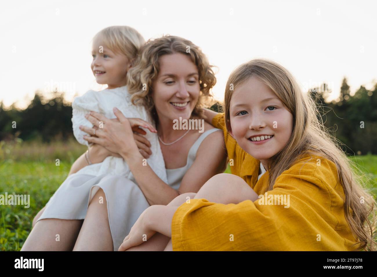 Lächelnde Mutter und Töchter verbringen Freizeit miteinander Stockfoto