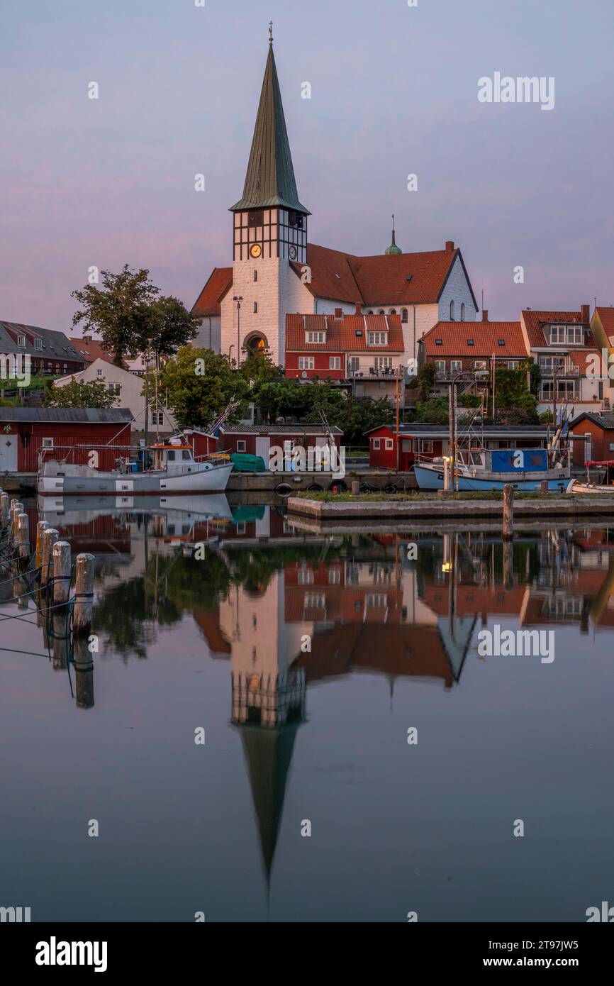 Dänemark, Bornholm, Ronne, St. Nikolaus Kirche reflektiert in der Abenddämmerung im Küstenwasser Stockfoto