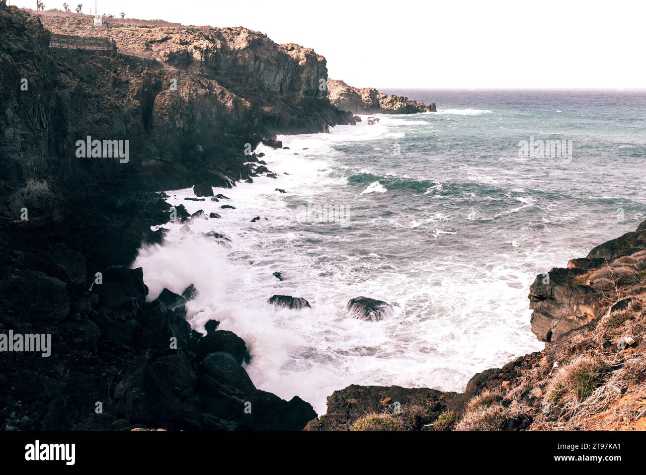 Küstenklippen mit Wellen, die über Felsen brechen Stockfoto