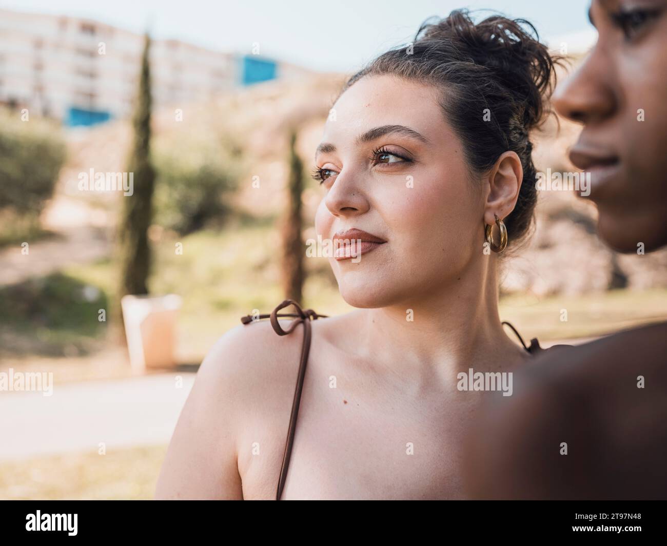 Kontemplative Frau mit Haargummi in der Nähe eines Freundes Stockfoto