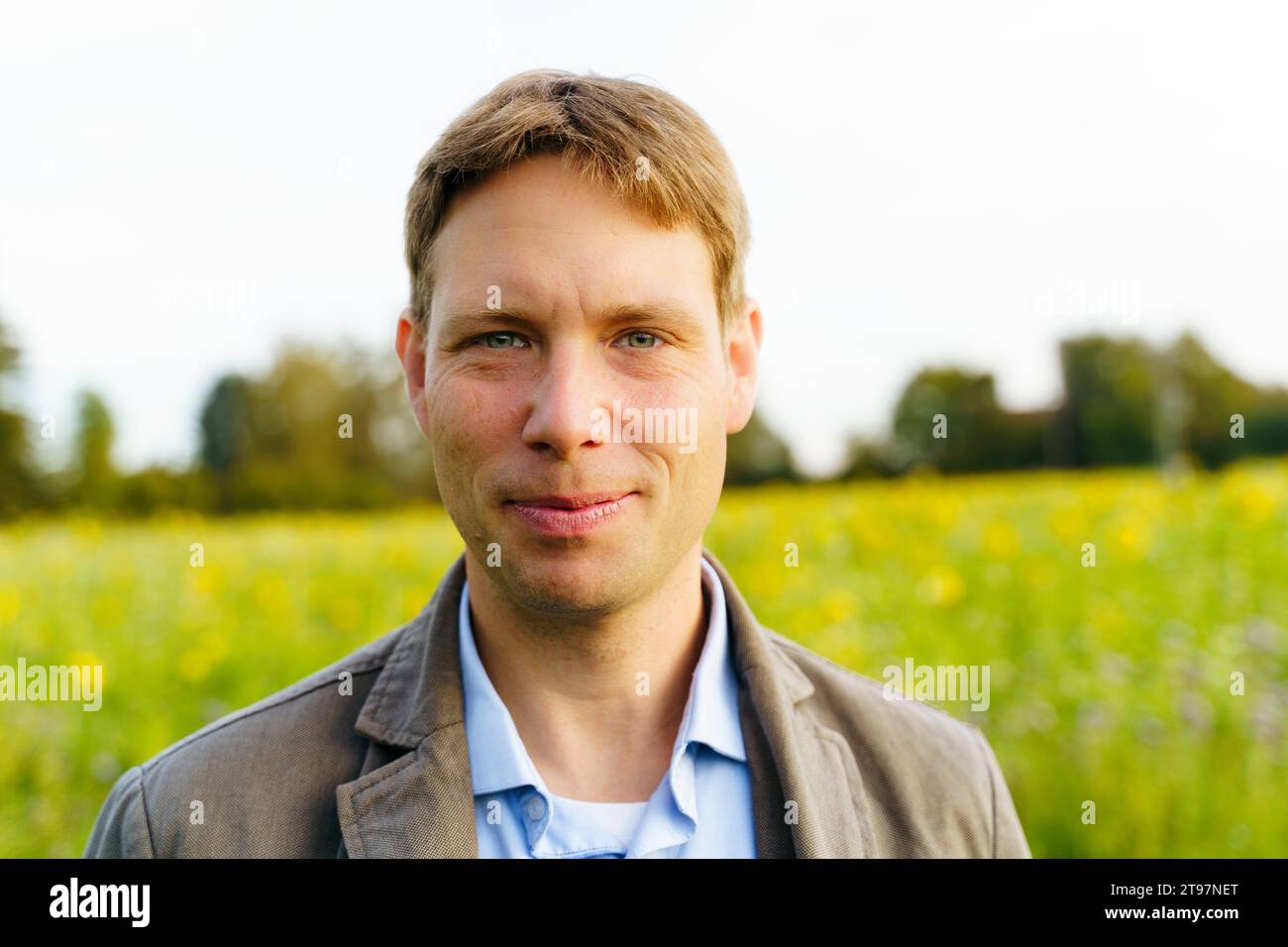Lächelnder Mann mit kurzen Haaren auf dem Feld Stockfoto