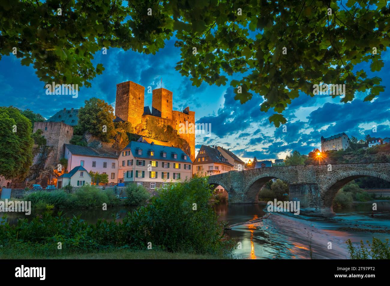 Deutschland, Hessen, Runkel, Bogenbrücke und Häuser vor Schloss Runkel in der Abenddämmerung Stockfoto