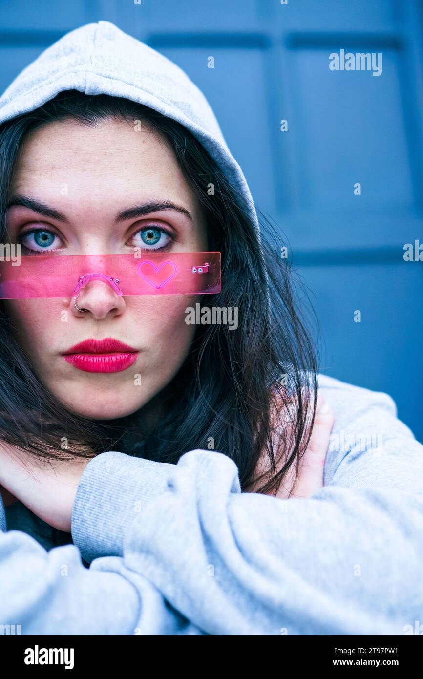 Eine junge Frau, die eine pinkfarbene Brille trägt Stockfoto