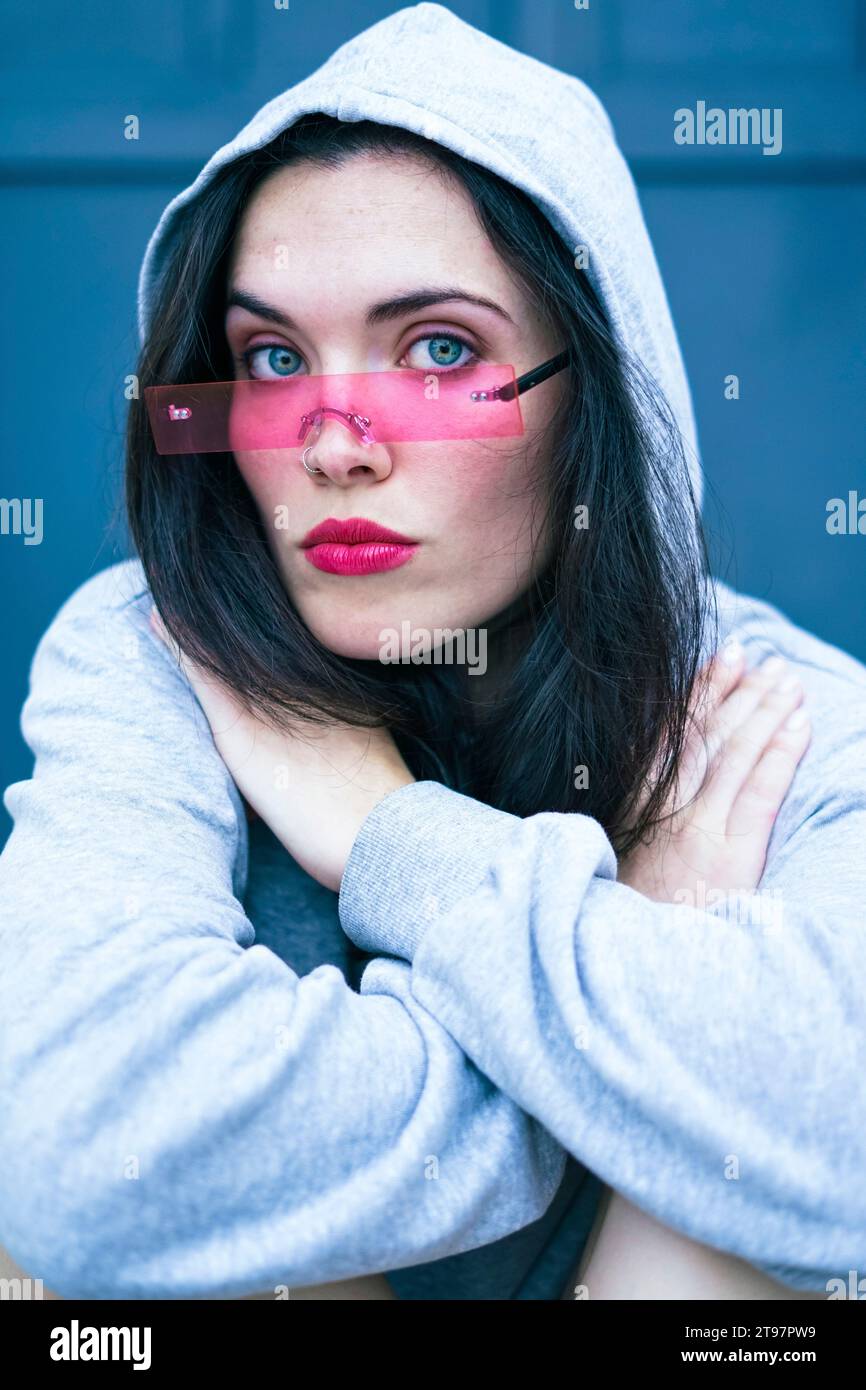Frau mit Kapuzenhemd und intelligenter Brille Stockfoto