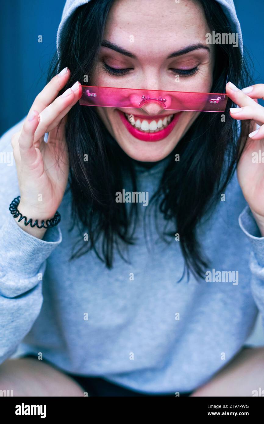 Glückliche Frau, die eine pinkfarbene Brille anpasst Stockfoto