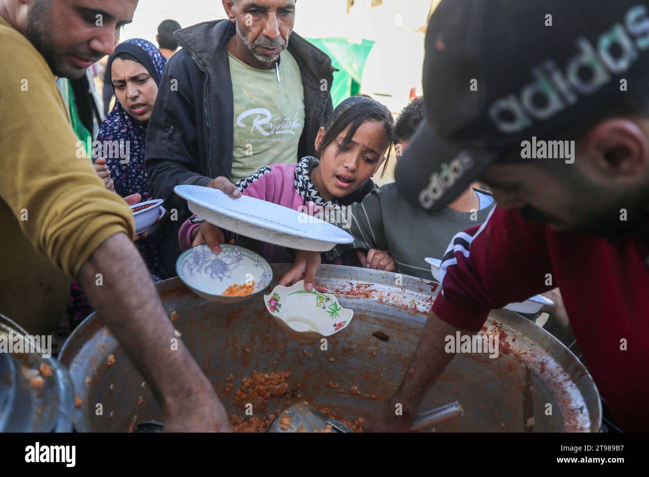 Vertriebene Palästinenser warten in der Schlange, während Freiwillige in Dair El-Balah im zentralen Gazastreifen eine Mahlzeit kochen. Vertriebene Palästinenser warten in der Schlange, während Freiwillige am 23. November 2023 im Dair El-Balah im zentralen Gazastreifen eine Mahlzeit kochen, während die Kämpfe zwischen Israel und Hamas-Militanten fortgesetzt werden. Foto: Majdi Fathi apaimages Dair El-Balah Gaza Streifen palästinensisches Gebiet 231123 Dair El-Balah MF 007 Copyright: XapaimagesxMajdixFathixapaimagesx Credit: Imago/Alamy Live News Stockfoto