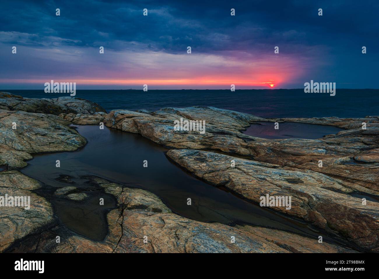 Wunderschöner Sonnenuntergang über dem felsigen Ufer der schwedischen Küste. Stockfoto