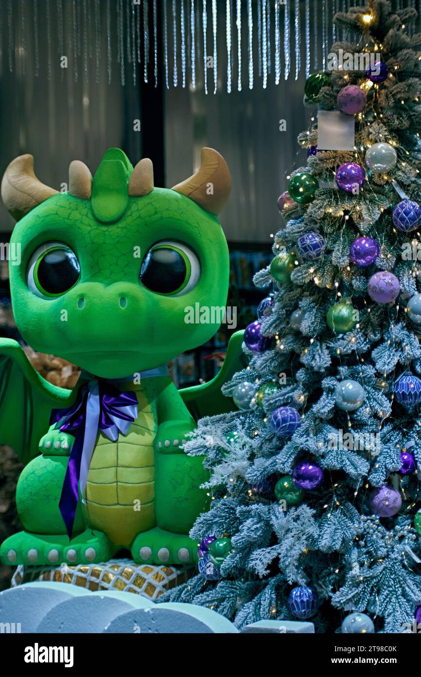 Blauer Weihnachtsbaum mit Kugeln und einem grünen Drachen in der Nähe. Weihnachtsdekoration Stockfoto