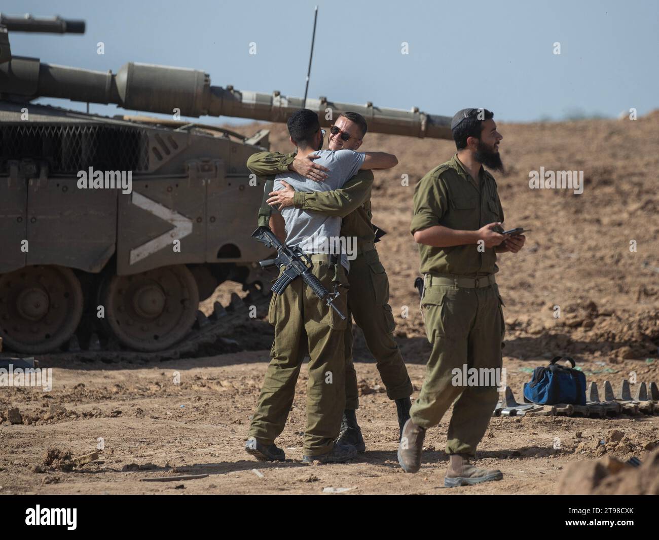 Süd-Israel, Israel. November 2023. Israelische Soldaten treffen sich und umarmen sich auf einer Basis im Süden Israels, wo am 23. November 2023 in der Nähe der Grenze zum Gazastreifen Panzerreparaturen durchgeführt werden. Morgen, am 24. November, sollen Israel und die Hamas einen Waffenstillstand beginnen und 50 israelische Geiseln gegen 150 in Israel inhaftierte Palästinenser austauschen. Der Waffenstillstand wird fünf Tage dauern und täglich etwa 12 Geiseln entlassen. Foto von Jim Hollander/UPI Credit: UPI/Alamy Live News Stockfoto