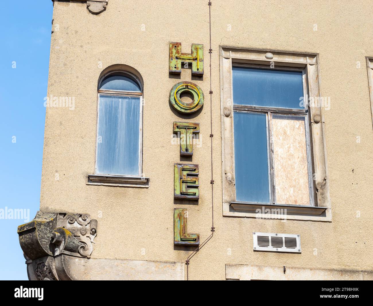 Heruntergekommenes Hotelschild an einer alten, verwitterten Gebäudefassade. Das Haus ist verlassen und das Geschäft ist geschlossen. Die Vintage-Werbung ist übrig. Stockfoto