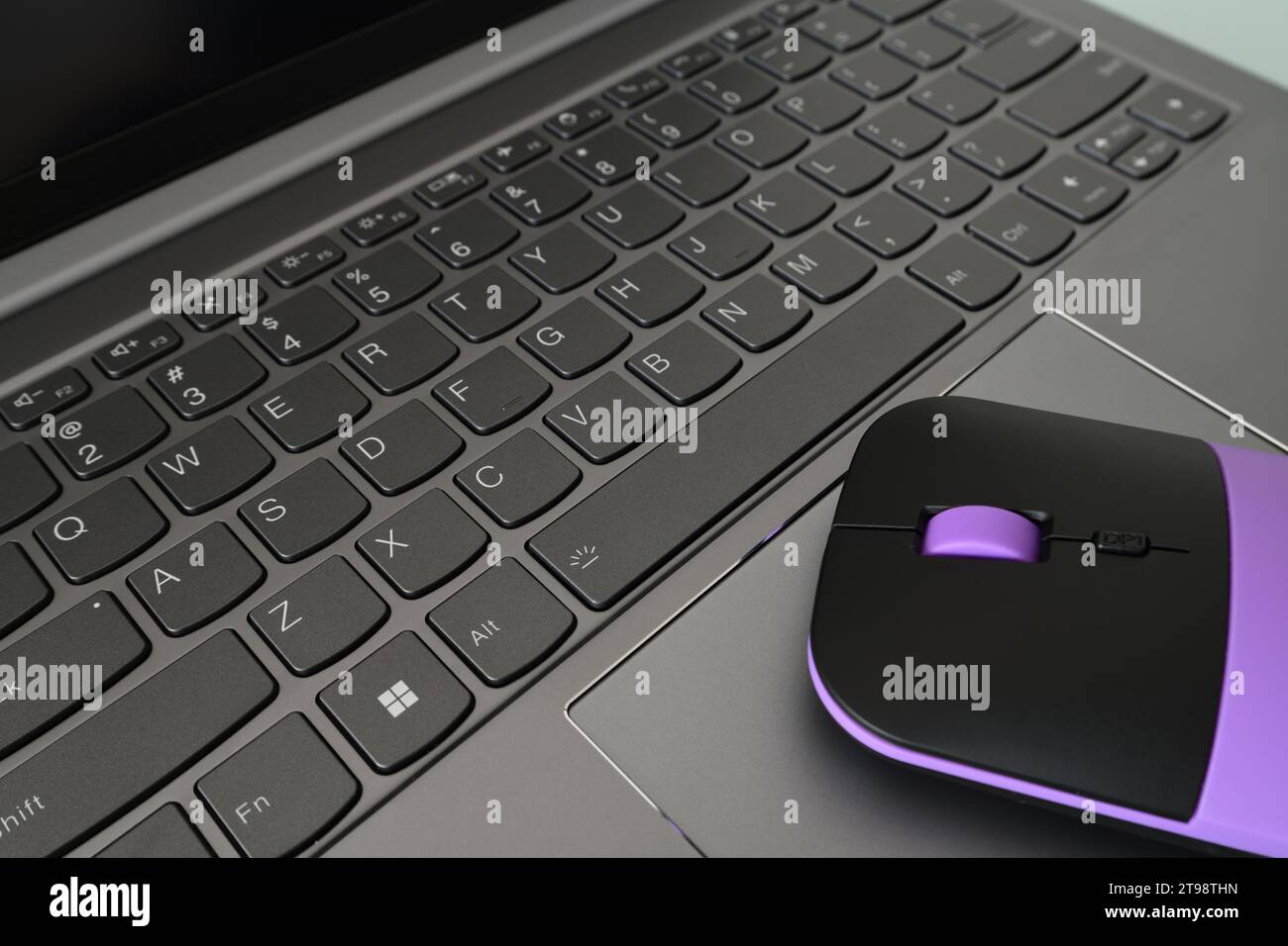 Die pinkfarbene Computermaus liegt auf der entsprechenden Tastatur Stockfoto