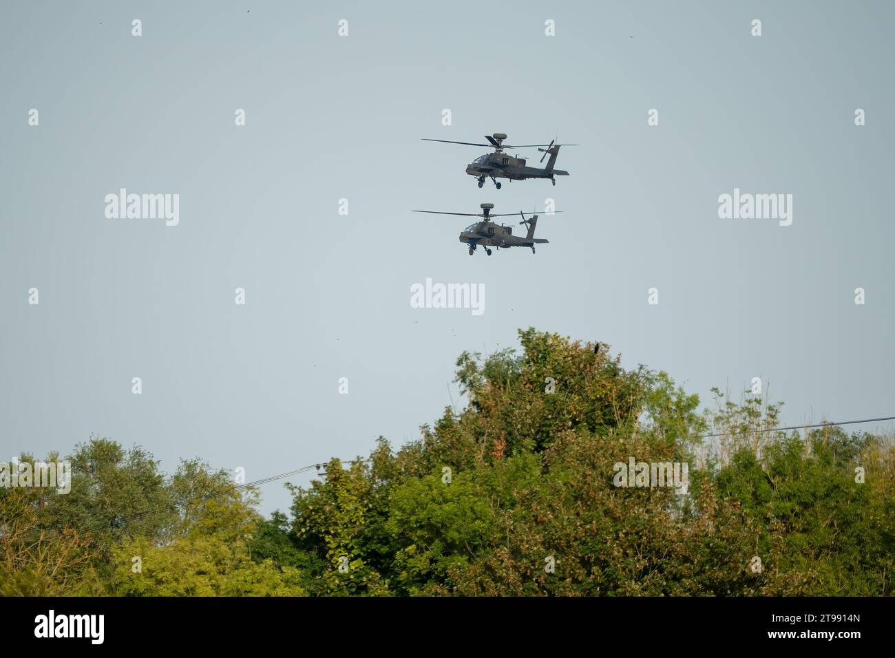 Ein Paar (zwei) britische Armee Boeing Apache Angriff Hubschrauber AH64E AH-64E im Tiefflug über die Sommerlandschaft Stockfoto
