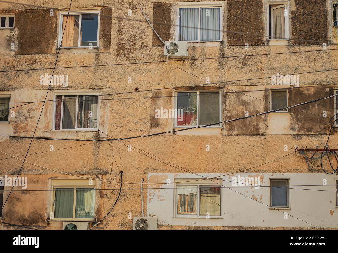 Alte Wohngebäude mit Schimmel an den Wänden. Altmodische Apartmenthäuser mit alten Fenstern. Schlechte Stadtlandschaft. Stockfoto