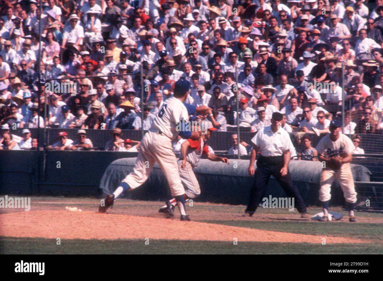 LOS ANGELES, KALIFORNIEN – 9. JULI: Pitcher Ron Perranoski #16 der Los Angeles Dodgers wirft auf den ersten Baseman Norm Larker #5, als Gene Freese #12 der Cincinnati Reds auf den ersten Platz zurückgeht, als der Schiedsrichter Tom Gorman während eines MLB-Spiels am 9. Juli auf den ersten Blick sieht. 1961 im Los Angeles Memorial Coliseum in Los Angeles, Kalifornien. (Foto von Hy Peskin) *** örtlicher Bildtitel *** Ron Perranoski;Norm Larker;Gene Freese;Tom Gorman Stockfoto
