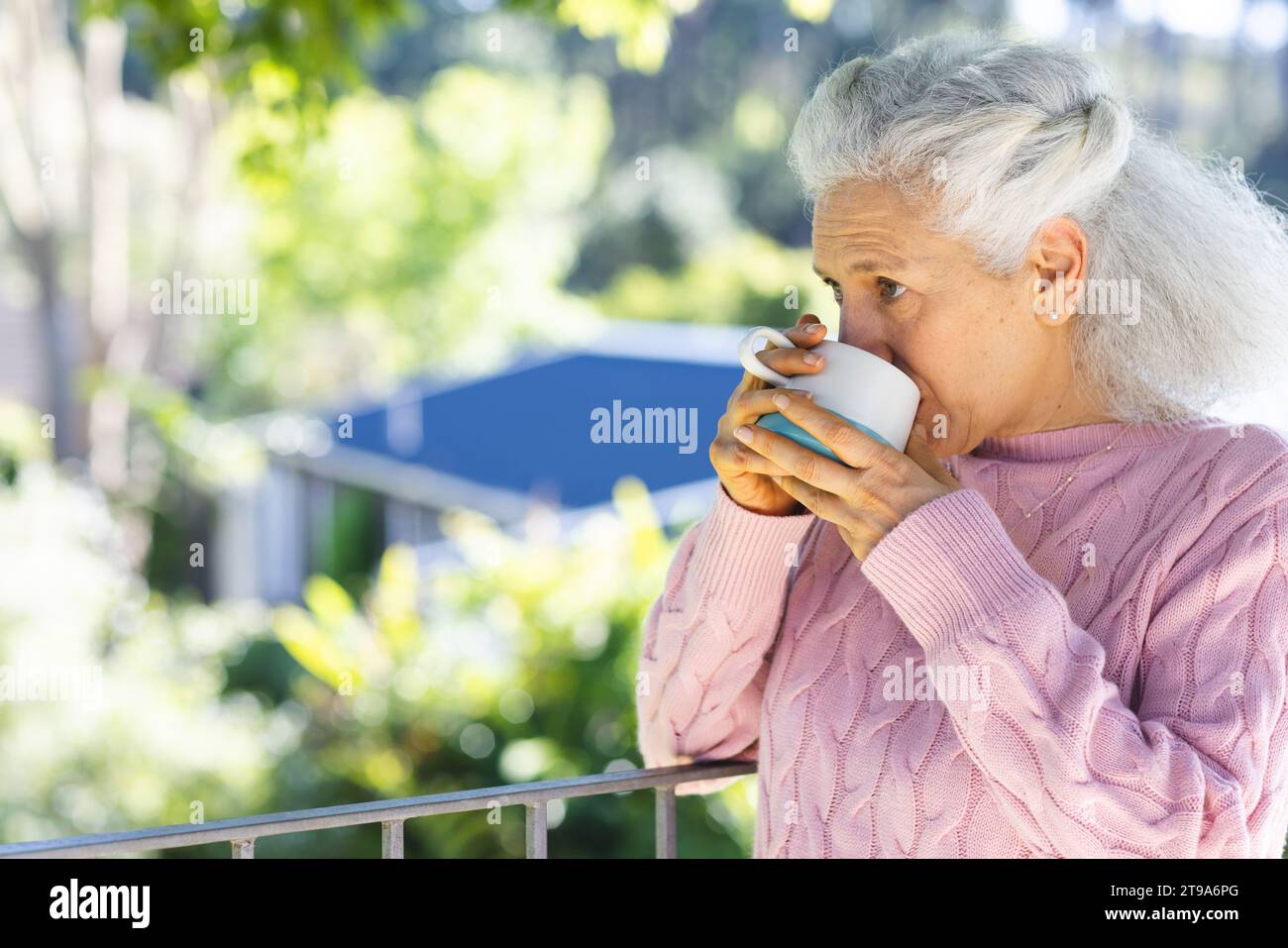 Kaukasische Seniorin trinkt Kaffee auf der Sonnenterrasse mit Kopierraum. Lebensstil, Ruhestand, Seniorenleben, Natur und häusliches Leben, unverändert. Stockfoto
