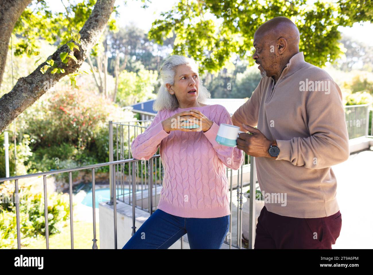 Diverse Seniorenpaare trinken Kaffee und unterhalten sich auf der sonnigen Terrasse. Lebensstil, Ruhestand, Seniorenleben, Natur, Zweisamkeit und häusliches Leben, u Stockfoto