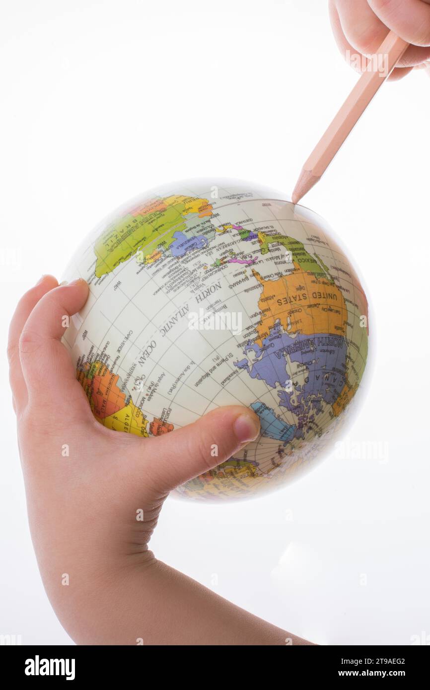 Kind hält einen Globus und einen Stift in auf weißem Hintergrund Stockfoto