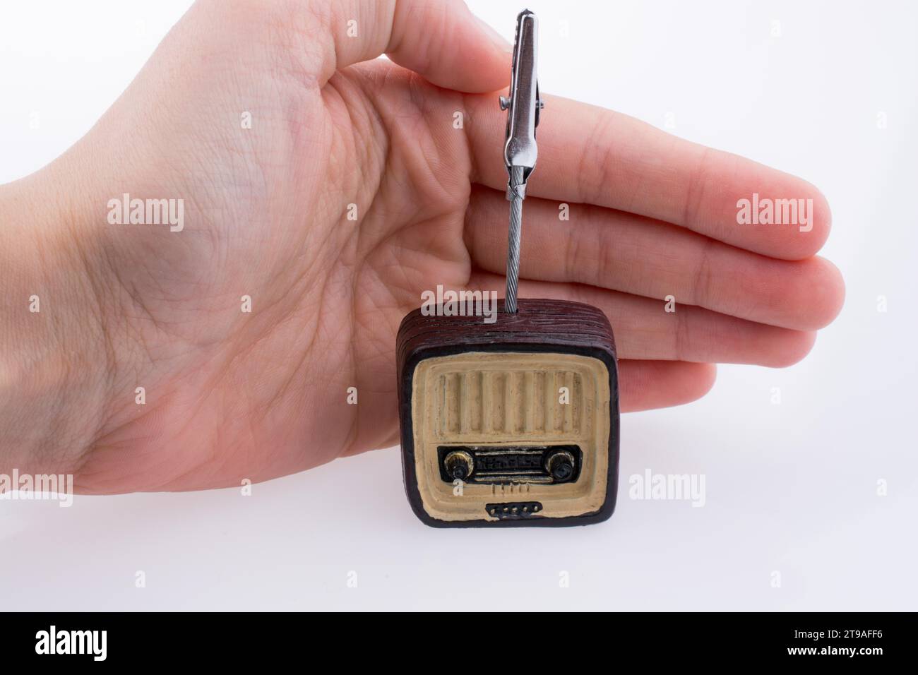 Hand mit einem Retro-TV-Modell auf einem weißen Hintergrund Stockfoto