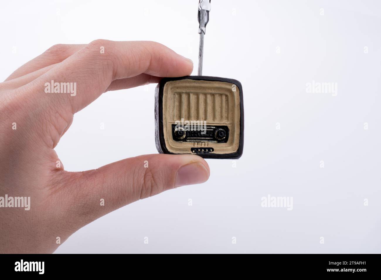 Hand mit einem Retro-TV-Modell auf einem weißen Hintergrund Stockfoto