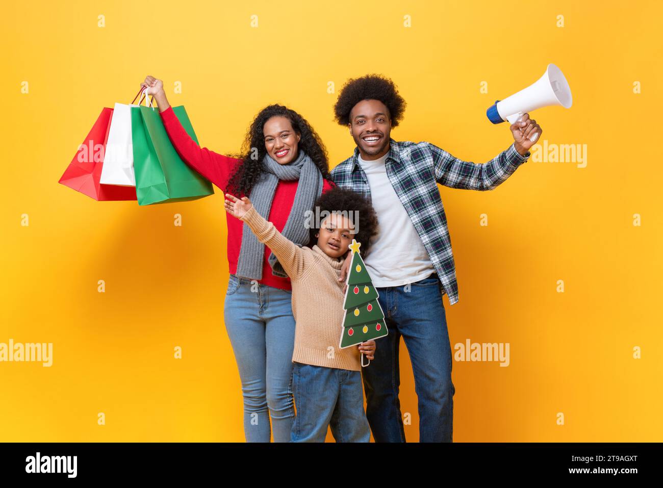 Fröhliche afroamerikanische Familie im festlichen Weihnachtsfeierstudio geschossen gelbe Farbe isolierten Hintergrund Stockfoto