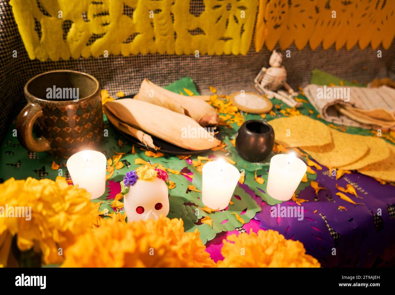 Ein Tag des toten Altars mit Schädeln, Cempasuchil-Blumen, Essen und Kerzen Stockfoto