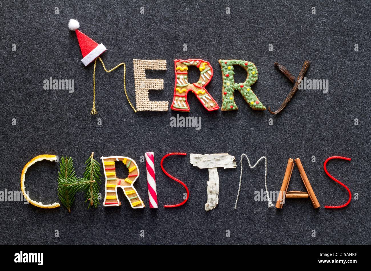 Merry christmas-Schriftzug aus verschiedenen weihnachtsprodukten auf dunklem Hintergrund Stockfoto