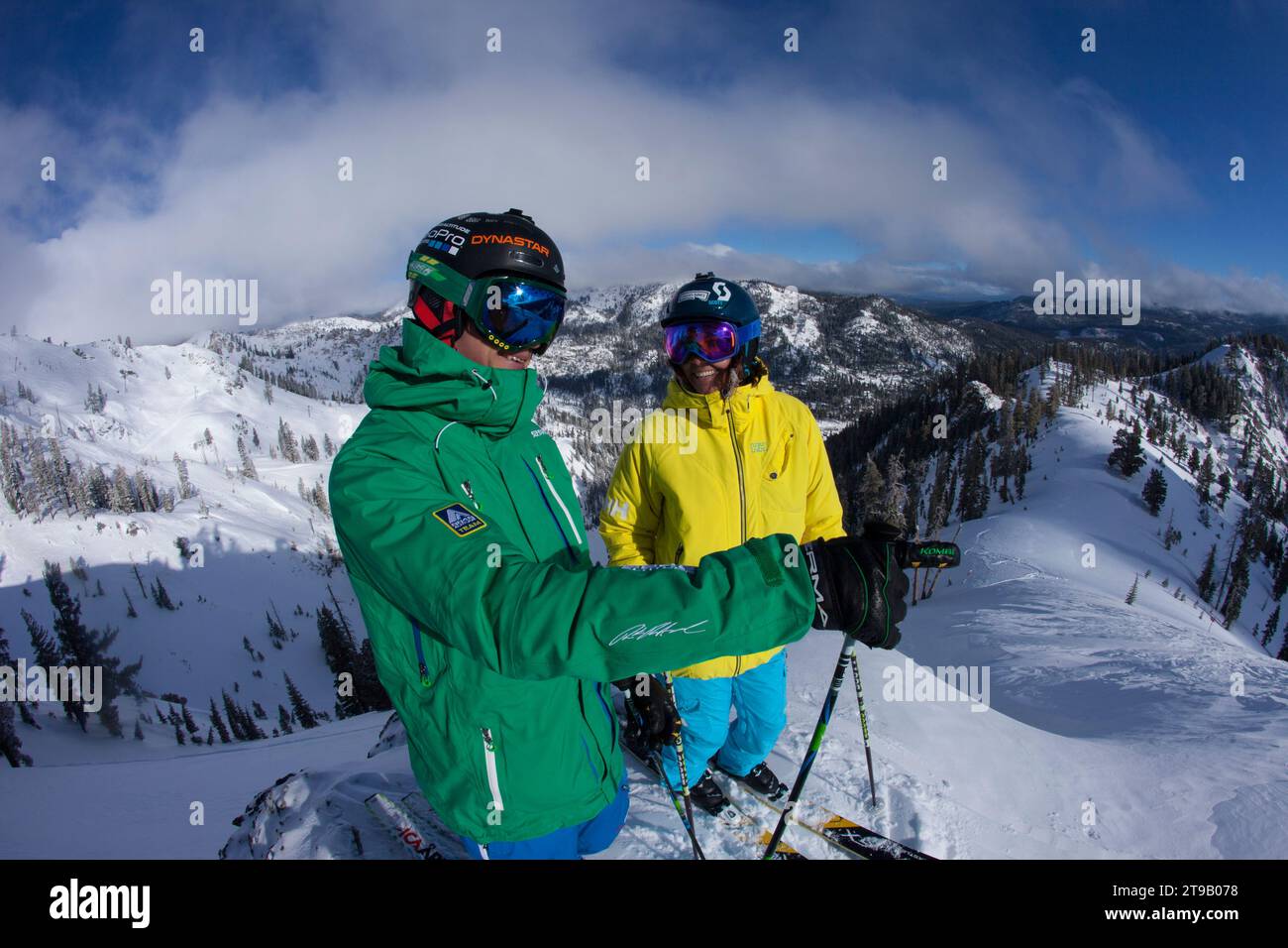 Zwei Erwachsene Skifahrer auf einem Bergrücken mit Blick auf die Berge. Stockfoto