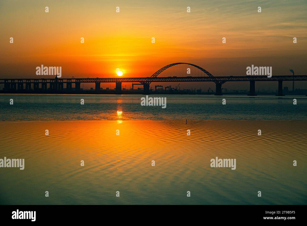 Sonnenaufgang auf dem Changjiang/Yangtze Fluss durch eine Stahlbrücke Stockfoto