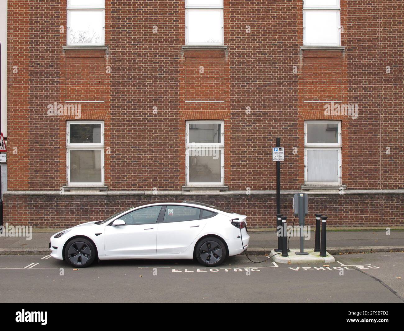 An Ladestationen für Straßenfahrzeuge in Leyton, London, Großbritannien. Ein Tesla-Auto, das an eine vom rat betriebene Ladestation für Elektrofahrzeuge angeschlossen ist. Stockfoto