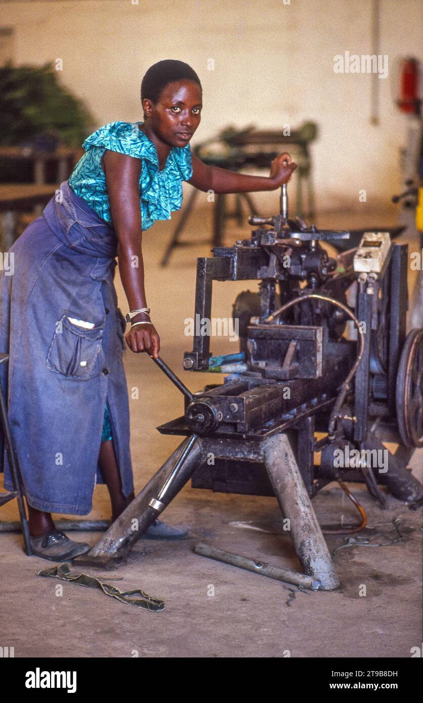 Tansania, Morogoro - Frau an einer Maschine in einer SIDO-Werkstatt. Stockfoto