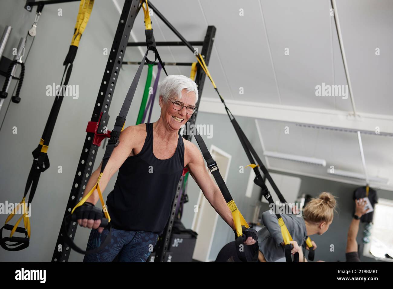Frau mit Trainingsgeräten im Fitnessstudio Stockfoto