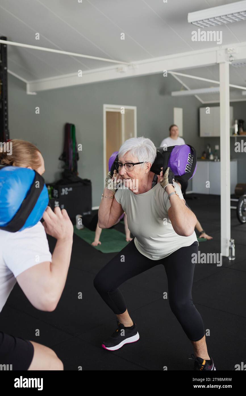 Frau, die mit Hantel mit Gewichten im Fitnessstudio trainiert Stockfoto