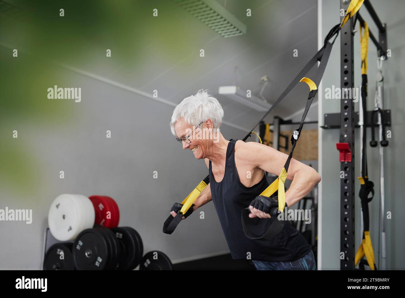 Frau mit Trainingsgeräten im Fitnessstudio Stockfoto