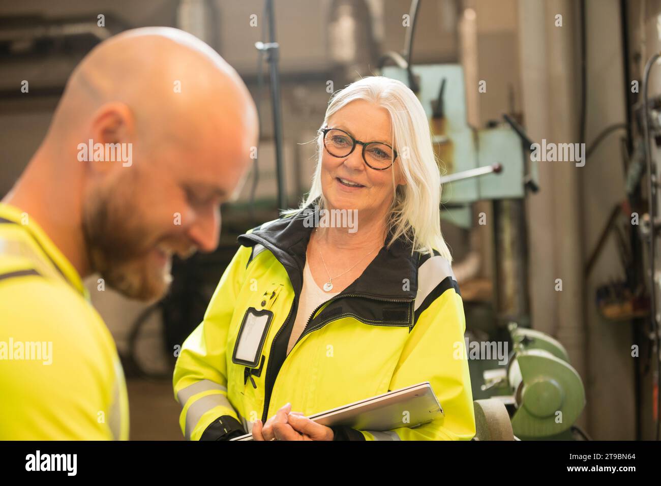 Männliche und weibliche Kollegen sprechen bei der Arbeit in der Werkstatt Stockfoto