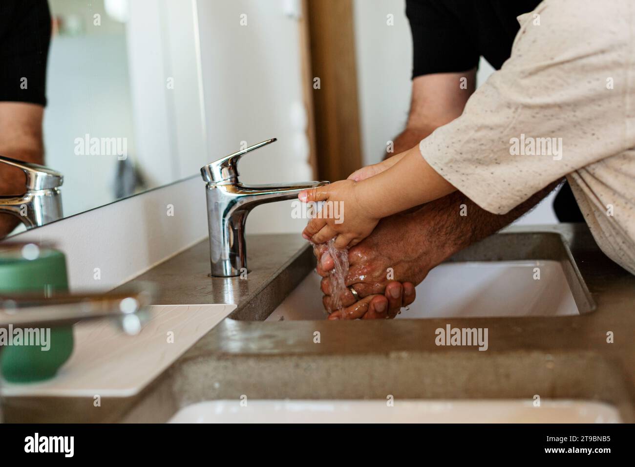 Mittelteil von Vater und Kind, die Hände waschen Stockfoto