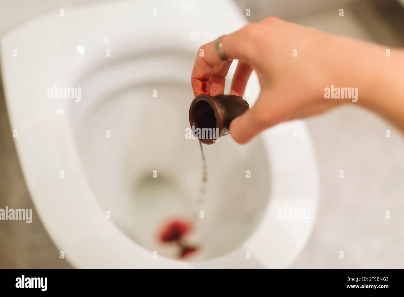Frau mit Menstruationstasse im Badezimmer Stockfoto