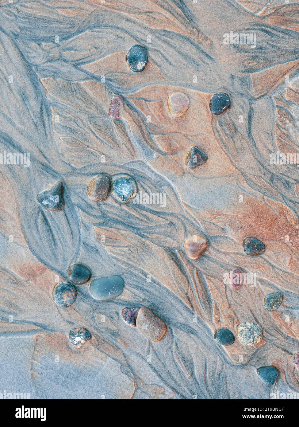 Nahaufnahme von Kieselsteinen und strukturiertem Sand Stockfoto